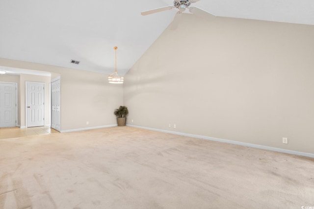 carpeted empty room with high vaulted ceiling and ceiling fan