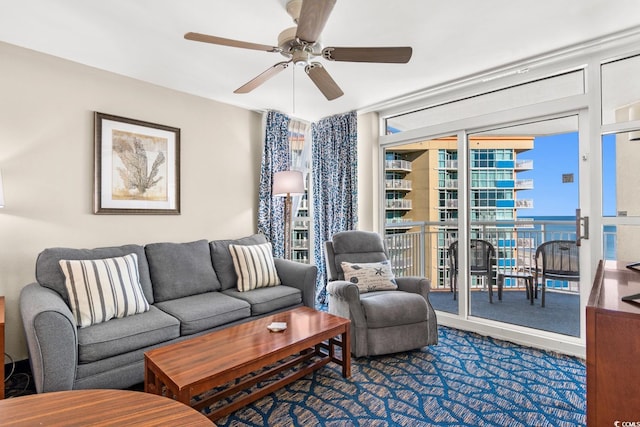 living room featuring plenty of natural light, ceiling fan, and a water view