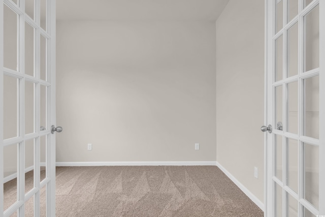 spare room with french doors, carpet, and baseboards