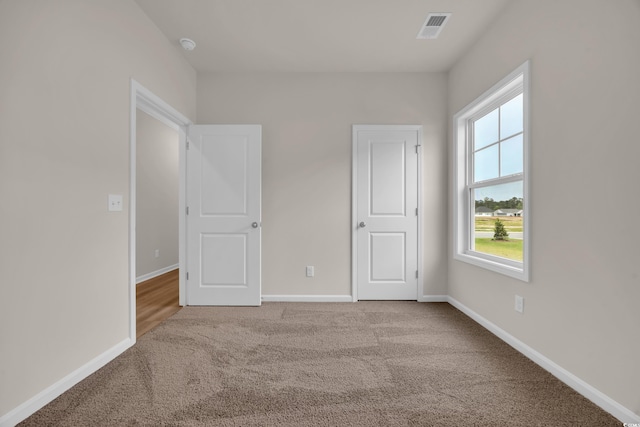 unfurnished bedroom featuring carpet flooring and baseboards