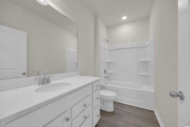 full bath with wood finished floors, vanity,  shower combination, toilet, and recessed lighting