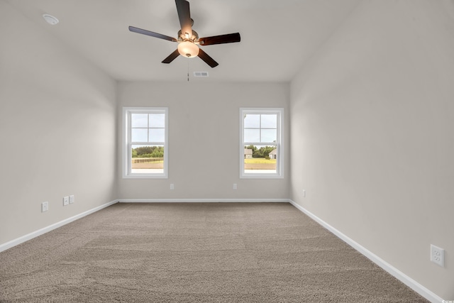 unfurnished room featuring plenty of natural light, ceiling fan, and baseboards
