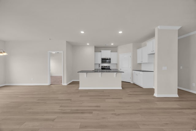 kitchen featuring appliances with stainless steel finishes, dark countertops, open floor plan, baseboards, and recessed lighting