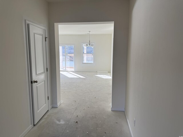 hallway with a notable chandelier