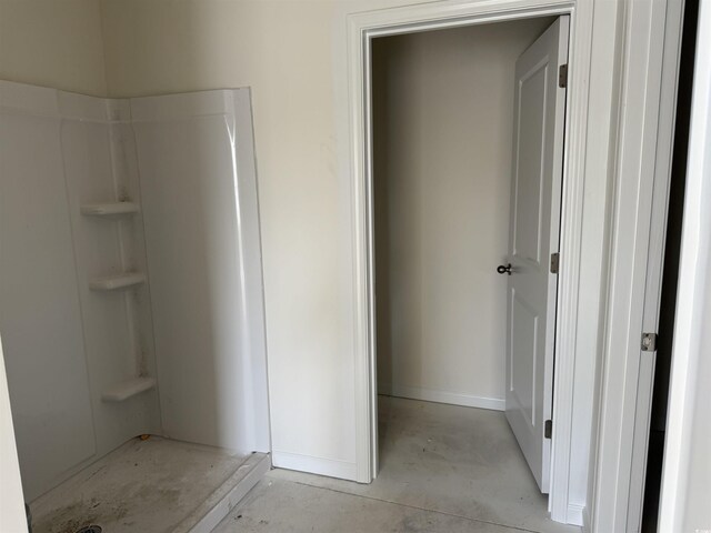 bathroom with concrete flooring and a shower