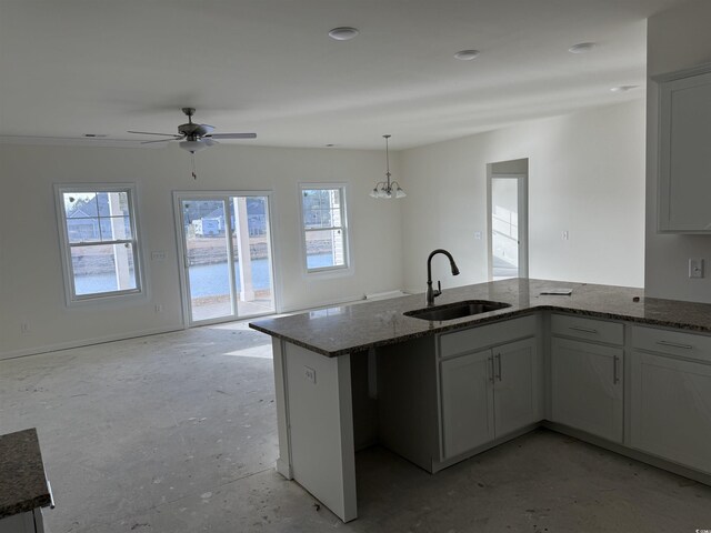 kitchen with white cabinetry, sink, plenty of natural light, and dark stone countertops