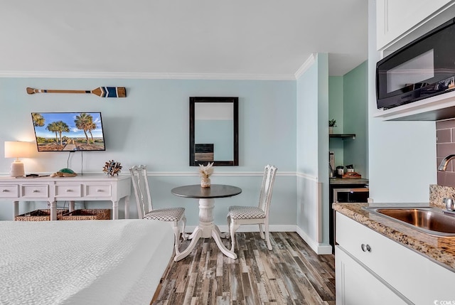 dining room featuring ornamental molding, sink, and hardwood / wood-style floors