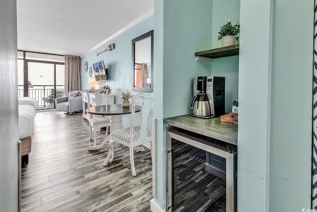 interior space featuring wine cooler, floor to ceiling windows, crown molding, and hardwood / wood-style flooring