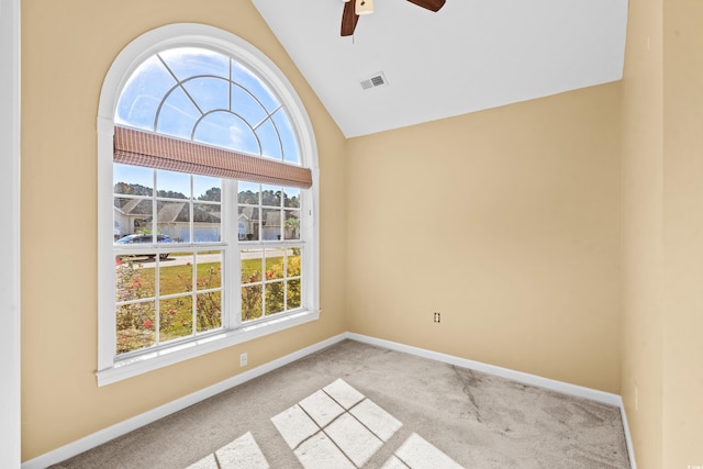 carpeted empty room featuring vaulted ceiling, ceiling fan, and a healthy amount of sunlight