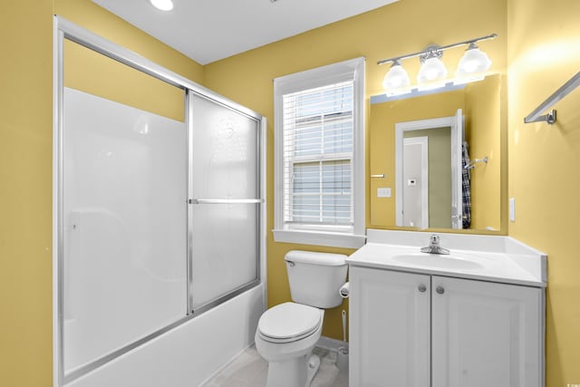 full bathroom featuring combined bath / shower with glass door, vanity, and toilet