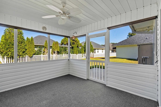 unfurnished sunroom with ceiling fan