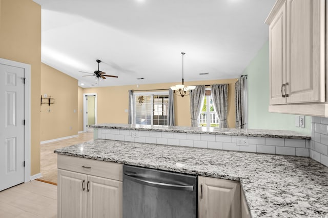 kitchen featuring ceiling fan with notable chandelier, dishwasher, light stone counters, and vaulted ceiling