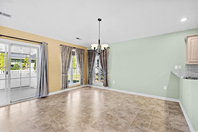 unfurnished dining area with a chandelier