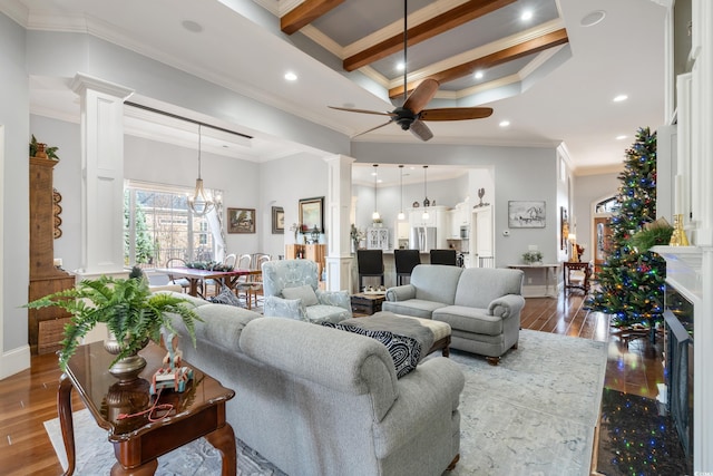 living room featuring hardwood / wood-style floors, ceiling fan with notable chandelier, ornamental molding, and beamed ceiling