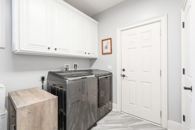 laundry area with cabinets and washer and clothes dryer