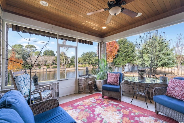 sunroom featuring a healthy amount of sunlight, a water view, and wood ceiling