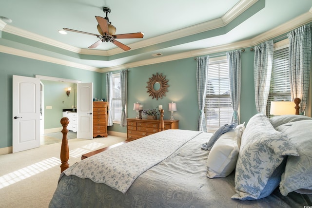 carpeted bedroom with a tray ceiling, ceiling fan, and crown molding