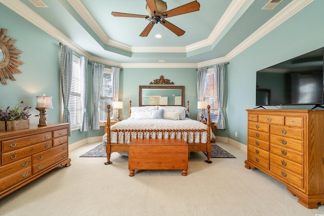 bedroom featuring a raised ceiling, ceiling fan, crown molding, and light carpet