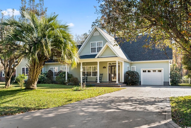 view of front of house with covered porch, a front yard, and a garage