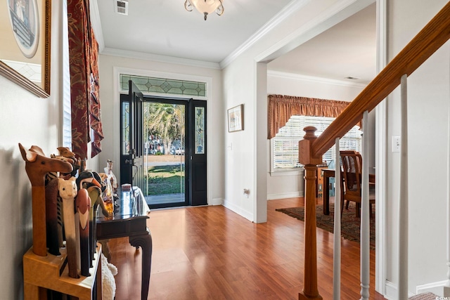 entrance foyer with hardwood / wood-style flooring and crown molding