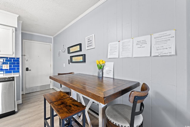 dining space featuring wooden walls, light hardwood / wood-style flooring, and crown molding