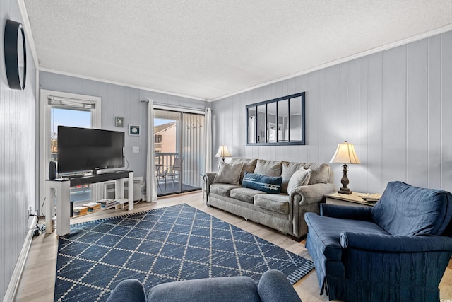 living room featuring a textured ceiling, hardwood / wood-style flooring, and crown molding