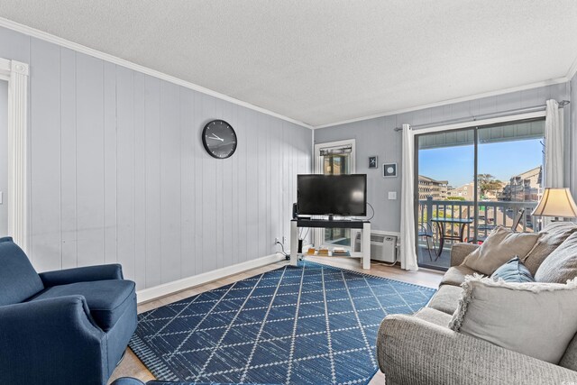 living room featuring hardwood / wood-style floors, crown molding, an AC wall unit, and a textured ceiling