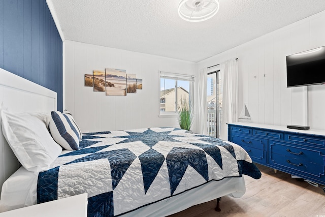 bedroom featuring light hardwood / wood-style flooring and a textured ceiling