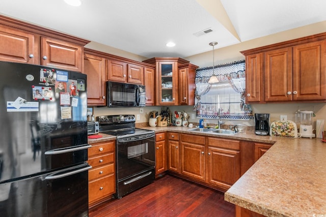 kitchen featuring black appliances, dark hardwood / wood-style floors, sink, and decorative light fixtures