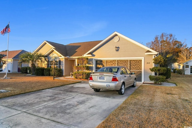 ranch-style house with a garage and a front lawn