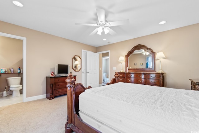 carpeted bedroom with ensuite bath and ceiling fan