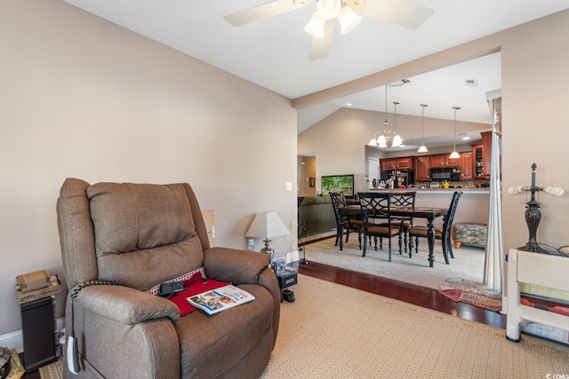 living room featuring ceiling fan with notable chandelier, lofted ceiling, and light hardwood / wood-style flooring