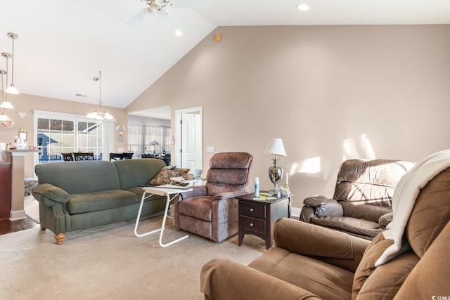 living room with high vaulted ceiling, light hardwood / wood-style floors, and ceiling fan with notable chandelier