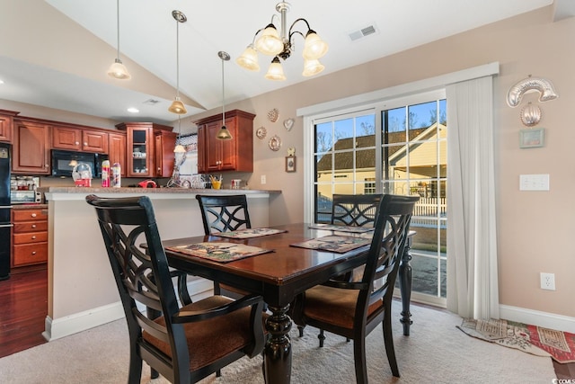 dining room featuring a chandelier, light hardwood / wood-style floors, and vaulted ceiling