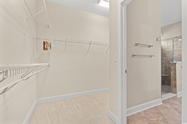 walk in closet with light tile patterned floors