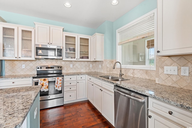 kitchen featuring decorative backsplash, appliances with stainless steel finishes, white cabinetry, and sink