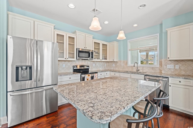 kitchen featuring a center island, sink, hanging light fixtures, a breakfast bar area, and stainless steel appliances