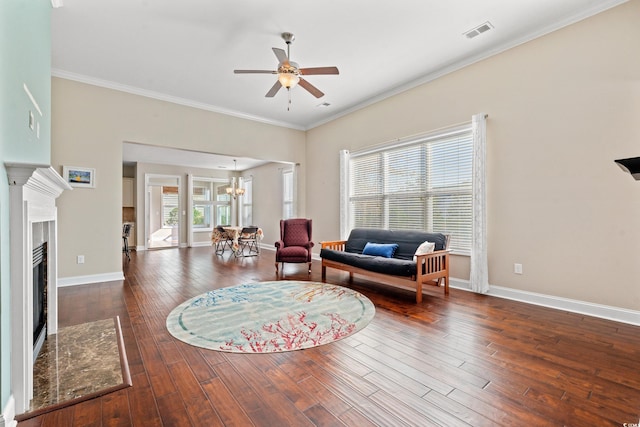 living room with a premium fireplace, plenty of natural light, dark wood-type flooring, and ceiling fan with notable chandelier