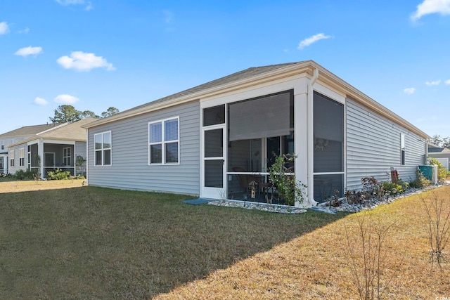 back of house with a lawn and a sunroom