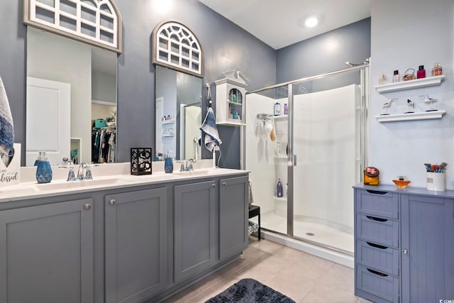 bathroom featuring tile patterned floors, a shower with door, and vanity