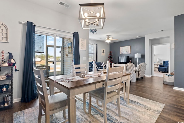 dining room featuring ceiling fan with notable chandelier and dark hardwood / wood-style floors