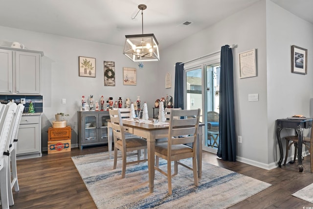 dining room with an inviting chandelier and dark wood-type flooring