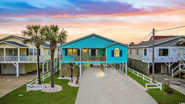 view of front of property featuring a carport and a yard