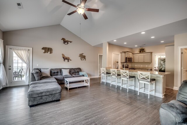 living room with dark hardwood / wood-style flooring, high vaulted ceiling, and ceiling fan