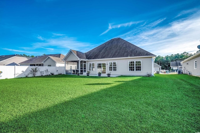 rear view of property with a lawn and cooling unit