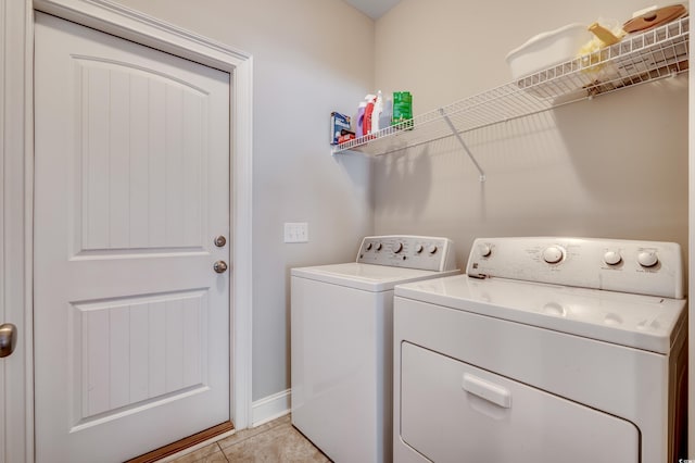 washroom featuring light tile patterned floors and washer and clothes dryer