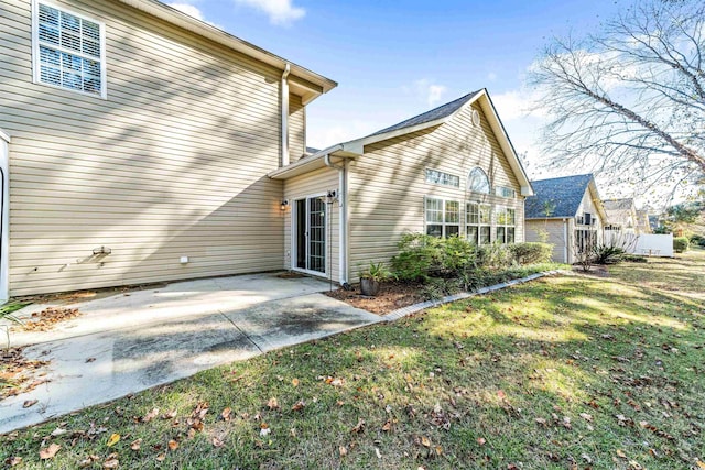 rear view of property with a lawn and a patio area