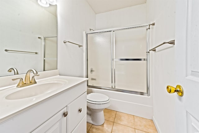 full bathroom with shower / bath combination with glass door, tile patterned flooring, vanity, and toilet