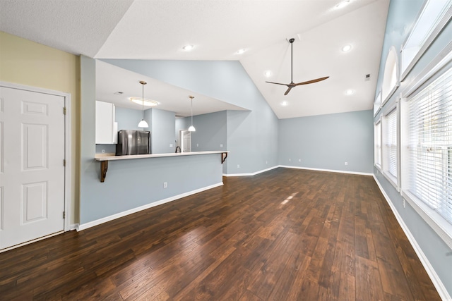 unfurnished living room featuring ceiling fan, dark hardwood / wood-style flooring, and high vaulted ceiling