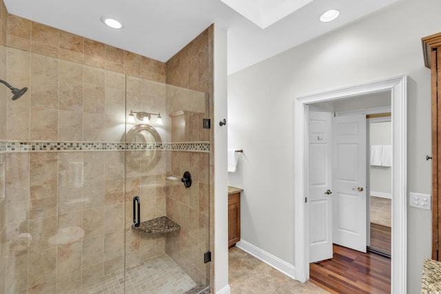 bathroom featuring a shower with door, vanity, and wood-type flooring